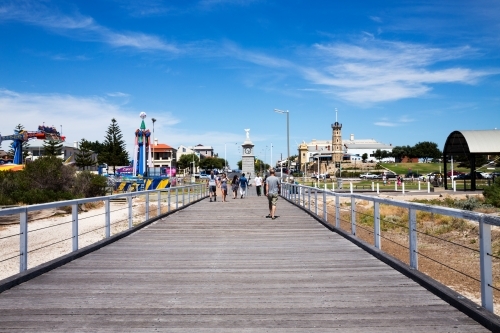 People walking on jetty with buildings in background - Australian Stock Image