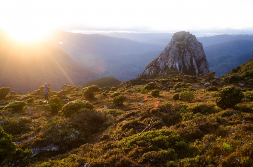 Person looking out at mountain range at sunset - Australian Stock Image