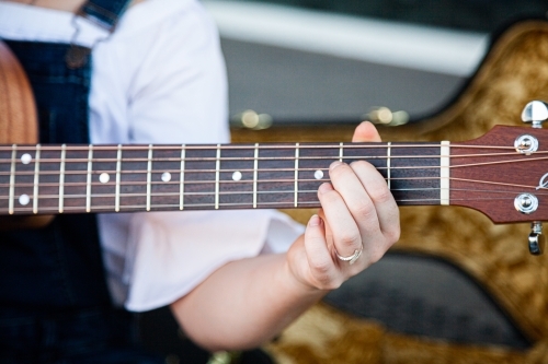Person playing chords on a guitar - Australian Stock Image