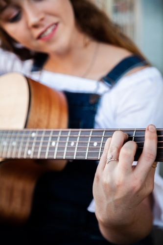 Person playing chords on a guitar - Australian Stock Image