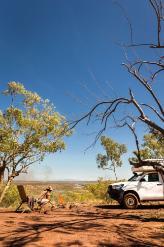 person relaxing in chair camping in Australian outback - Australian Stock Image
