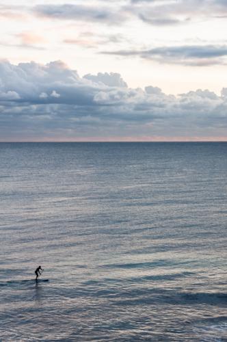 Person Riding on Stand up Paddleboard with Ocean and Horizon