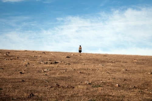 Person standing alone on a hill - Australian Stock Image