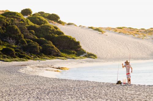 Person standing on the beach Fishing