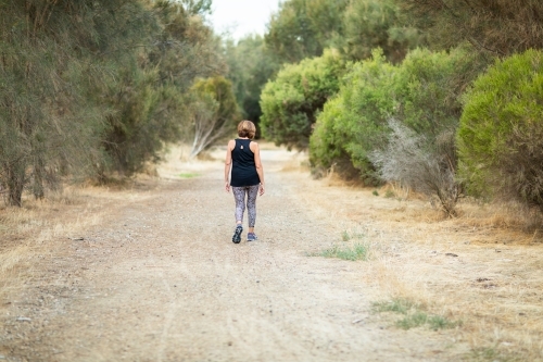 person walking away down country lane - Australian Stock Image