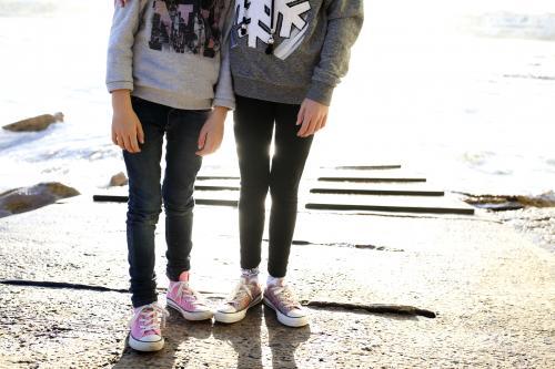 Photo of girls legs standing on boat ramp by the ocean - Australian Stock Image