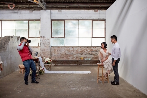 Photographer taking photos in warehouse of wedding couple
