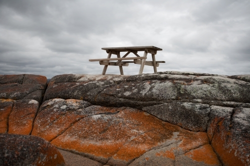 picnic table situated on lichen covered rocks