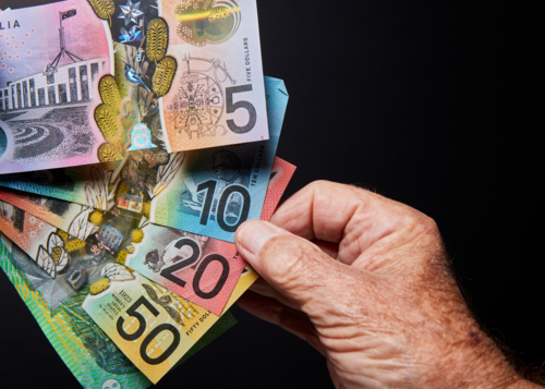 banknotes with hand on black background - Australian Stock Image