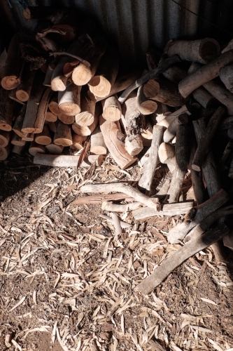 Pile of firewood in sunlit shed - Australian Stock Image