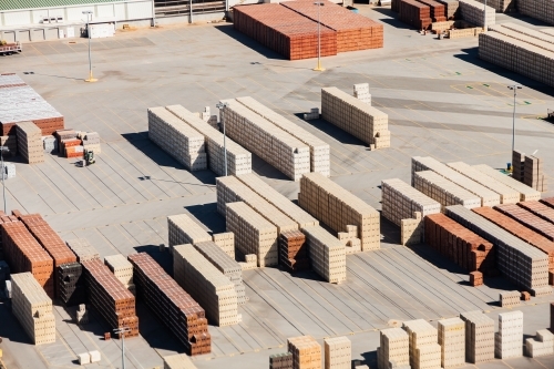 Piles of bricks in store area in industrial area of city - Australian Stock Image