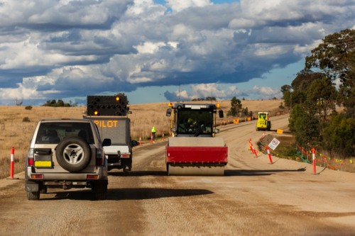 Pilot vehicle do not overtake leading the way through resurfacing earthworks on rural road - Australian Stock Image