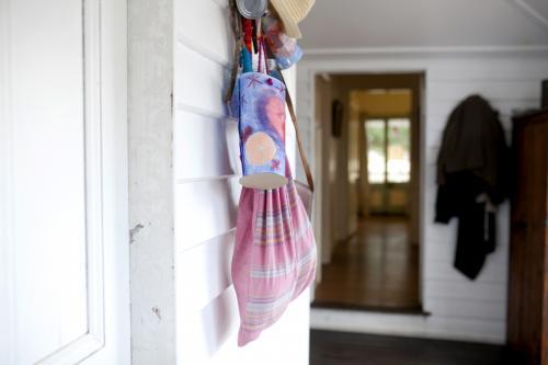 Pink bags hanging from coat hook near doorway - Australian Stock Image