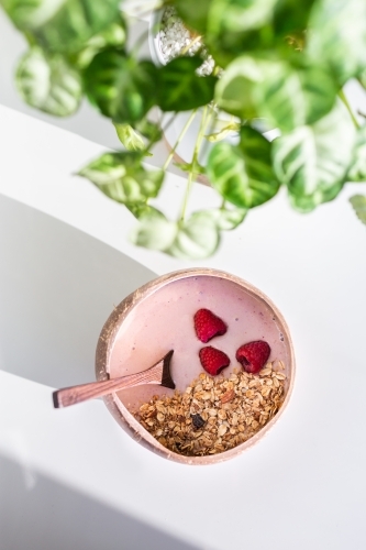 Pink strawberry smoothie bowl with muesli and raspberries for breakfast - Australian Stock Image