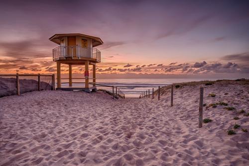 Pink Sunrise Over Ocean with Lifegaurd Tower in Foreground