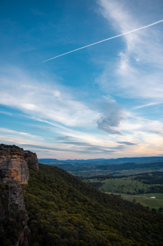 Plane trail in the sky over a cliff - Australian Stock Image