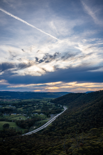 Plane trail in the sunset sky Hassan's wall, Lithgow - Australian Stock Image