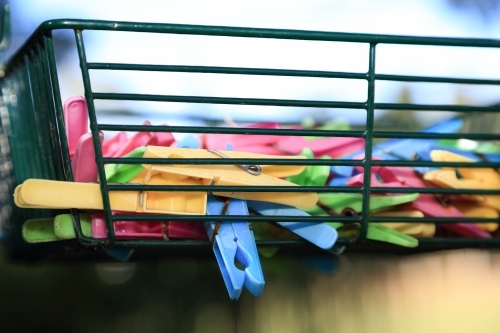 Plastic pegs in a wire basket. - Australian Stock Image