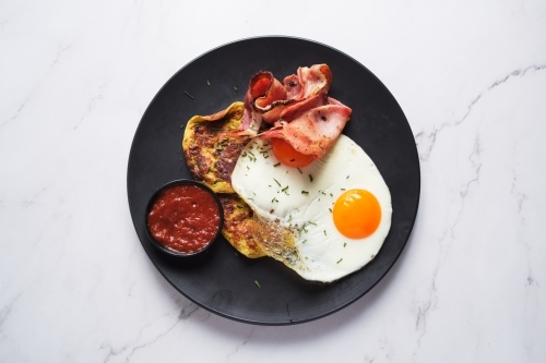 Plate of breakfast food with eggs and bacon - Australian Stock Image