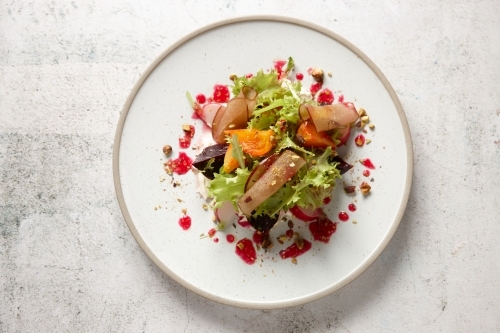 Plate of fresh salad of lettuce, beetroot, radish and stone fruit - from above - Australian Stock Image