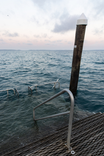 platform at the end of a jetty under water at high tide before dawn - Australian Stock Image