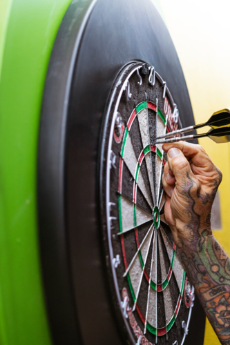Player collecting Darts from Dart Board - Australian Stock Image