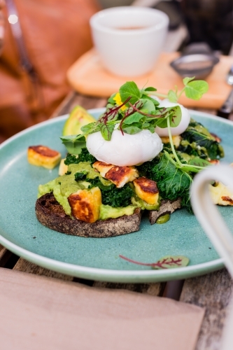 poached eggs with halloumi, avo and rye bread - Australian Stock Image