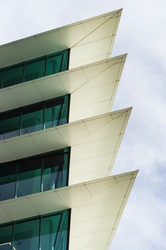 Pointed cement protrusions between glass windows of a modern high rise building - Australian Stock Image