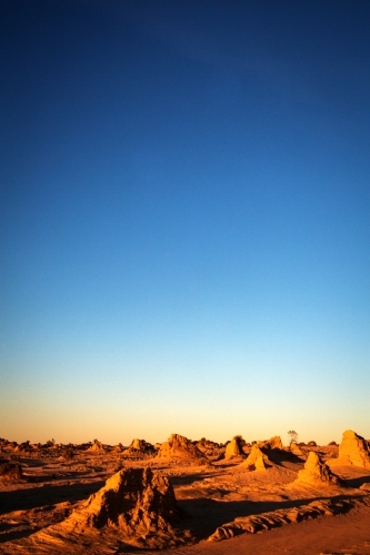pointy rocks on the ground with sand with blue skies - Australian Stock Image