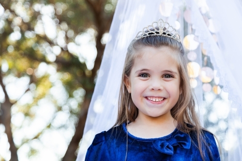 Portrait of a child playing dress ups as a princess with a silver tiara - Australian Stock Image