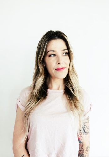 Portrait of a girl with arm tattoos looking sideways - Australian Stock Image