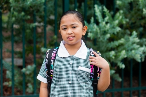 Portrait of a happy school girl with her bag on ready to go back to school - Australian Stock Image