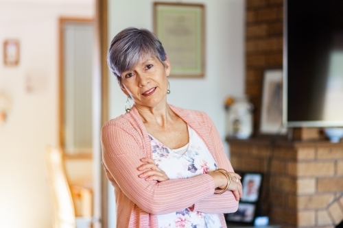 Portrait of a happy senior woman in her living room - Australian Stock Image