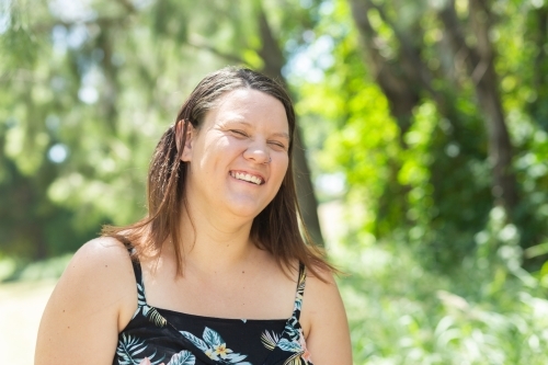 Portrait of a happy woman grinning outside in summer