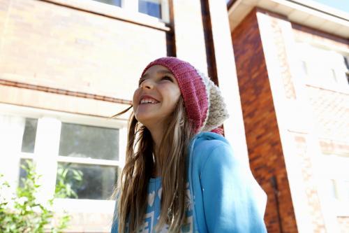 Portrait of a happy young girl in the sunshine looking away - Australian Stock Image