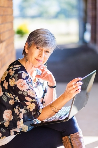 portrait of a senior woman on laptop outside - Australian Stock Image