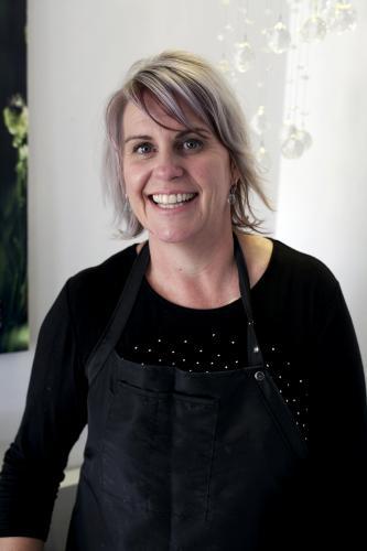 Portrait of a smiling hairdresser wearing an apron