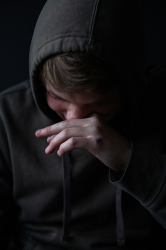 Portrait of a teenage boy laughing and looking down - Australian Stock Image