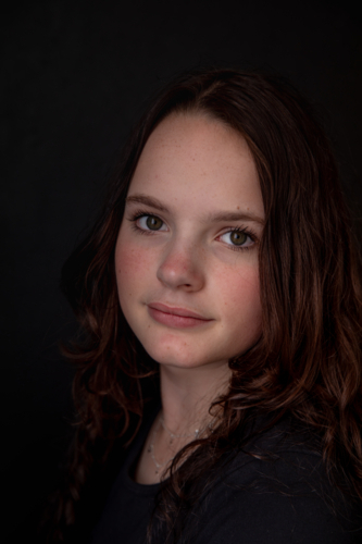 Portrait of a teenage girl with long hair smiling - Australian Stock Image