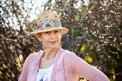 Portrait of a woman in a hat in the garden - Australian Stock Image