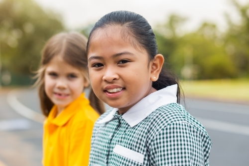 Portrait of a young Australian girl of Filipino ethnicity sitting outside school - Australian Stock Image