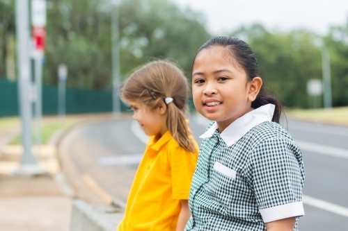 Portrait of a young Australian girl of Filipino ethnicity sitting outside school - Australian Stock Image