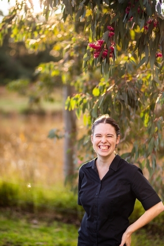 Portrait of a young businesswoman under pink gum blossoms - Australian Stock Image