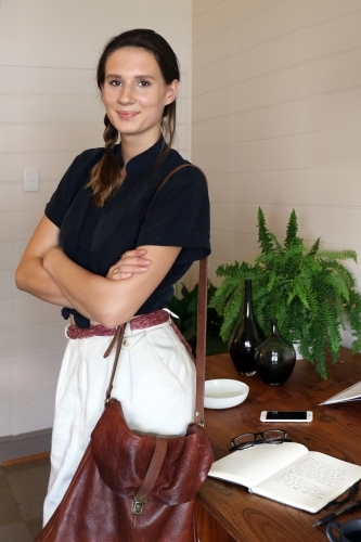 Portrait of a young creative female worker standing at her office desk - Australian Stock Image