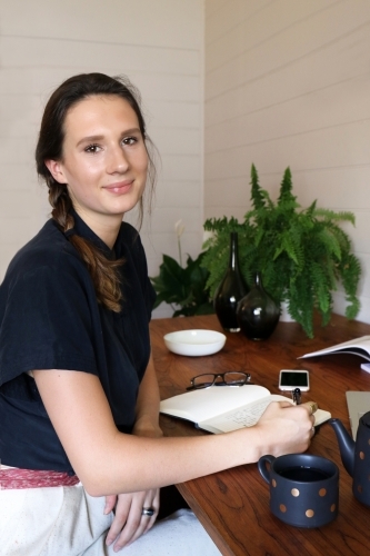 Portrait of a young female creative industry worker sitting at her desk - Australian Stock Image