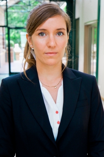 Portrait of a young female office worker standing near the exit of the building - Australian Stock Image