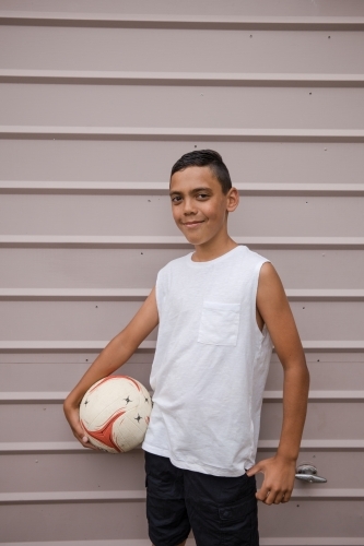 Portrait of a young first nations boy holding a soccer ball - Australian Stock Image