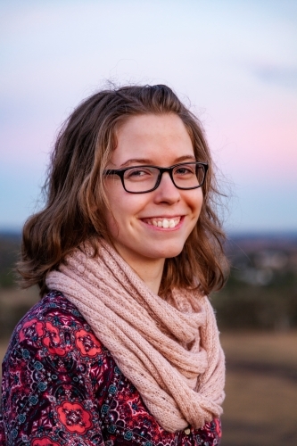 Portrait of a young lady wearing glasses in winter in pastel dusk light - Australian Stock Image