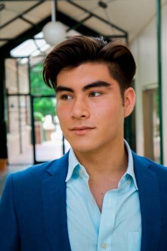 Portrait of a young male office worker standing near the exit of the building - Australian Stock Image