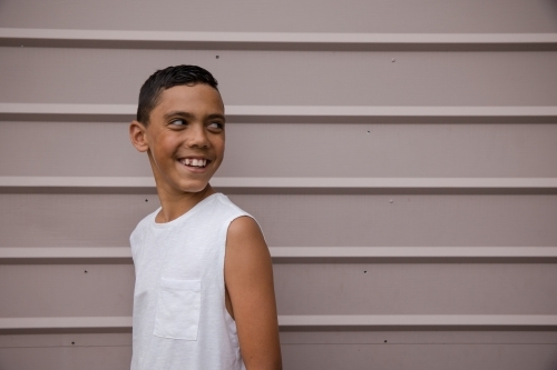 Portrait of a young, smiling first nations boy looking away - Australian Stock Image